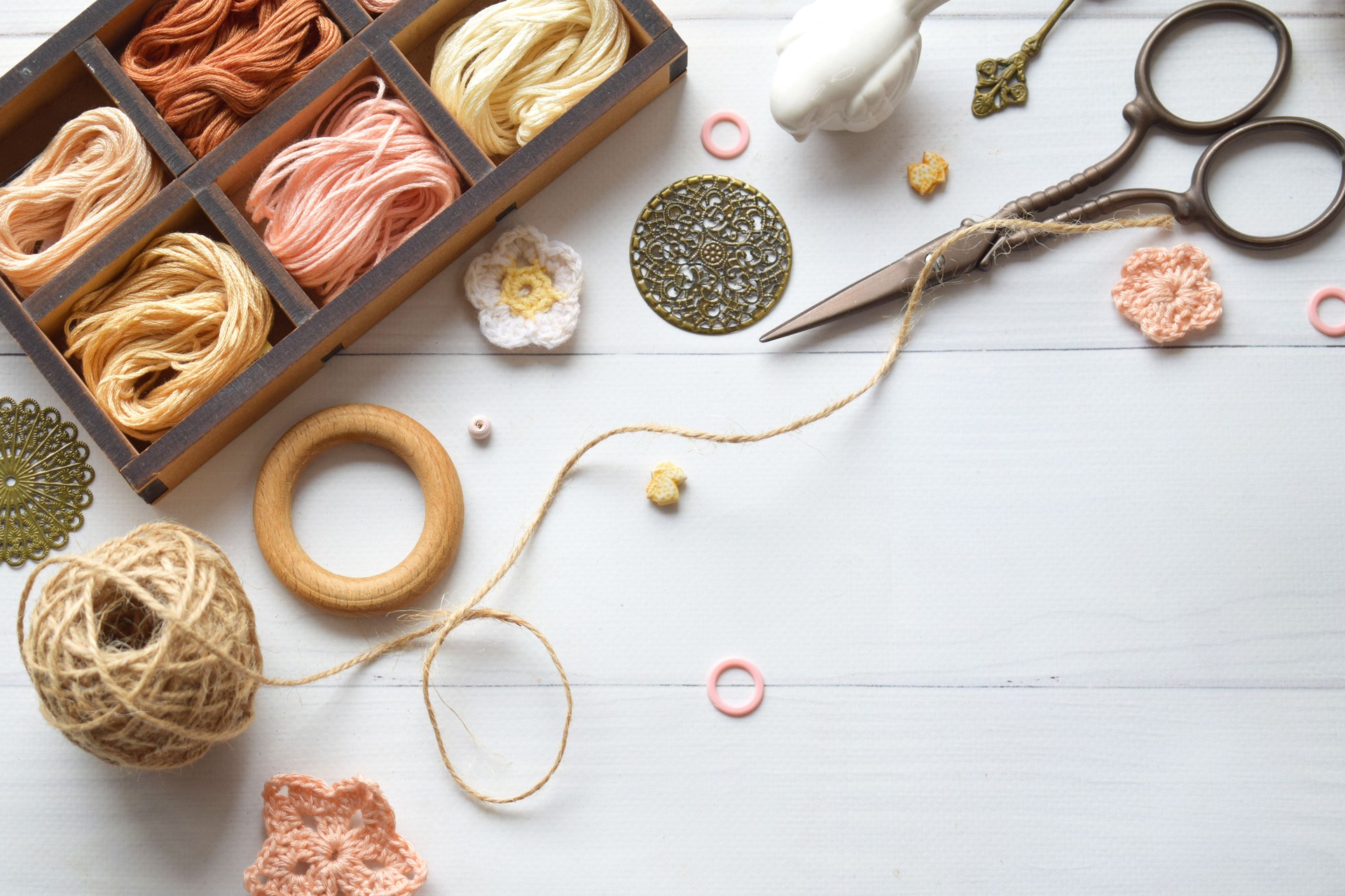 Handmade crafts workspace with yarn threads scissors and crochet hooks on a rustic white table perfect for DIY projects creative hobbies and artisan designs